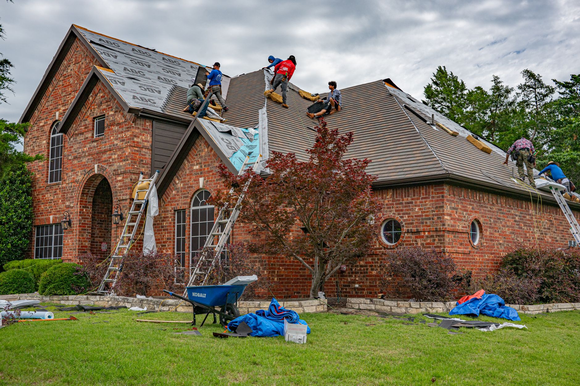 Professional roofing team installing new roof shingles on residential home