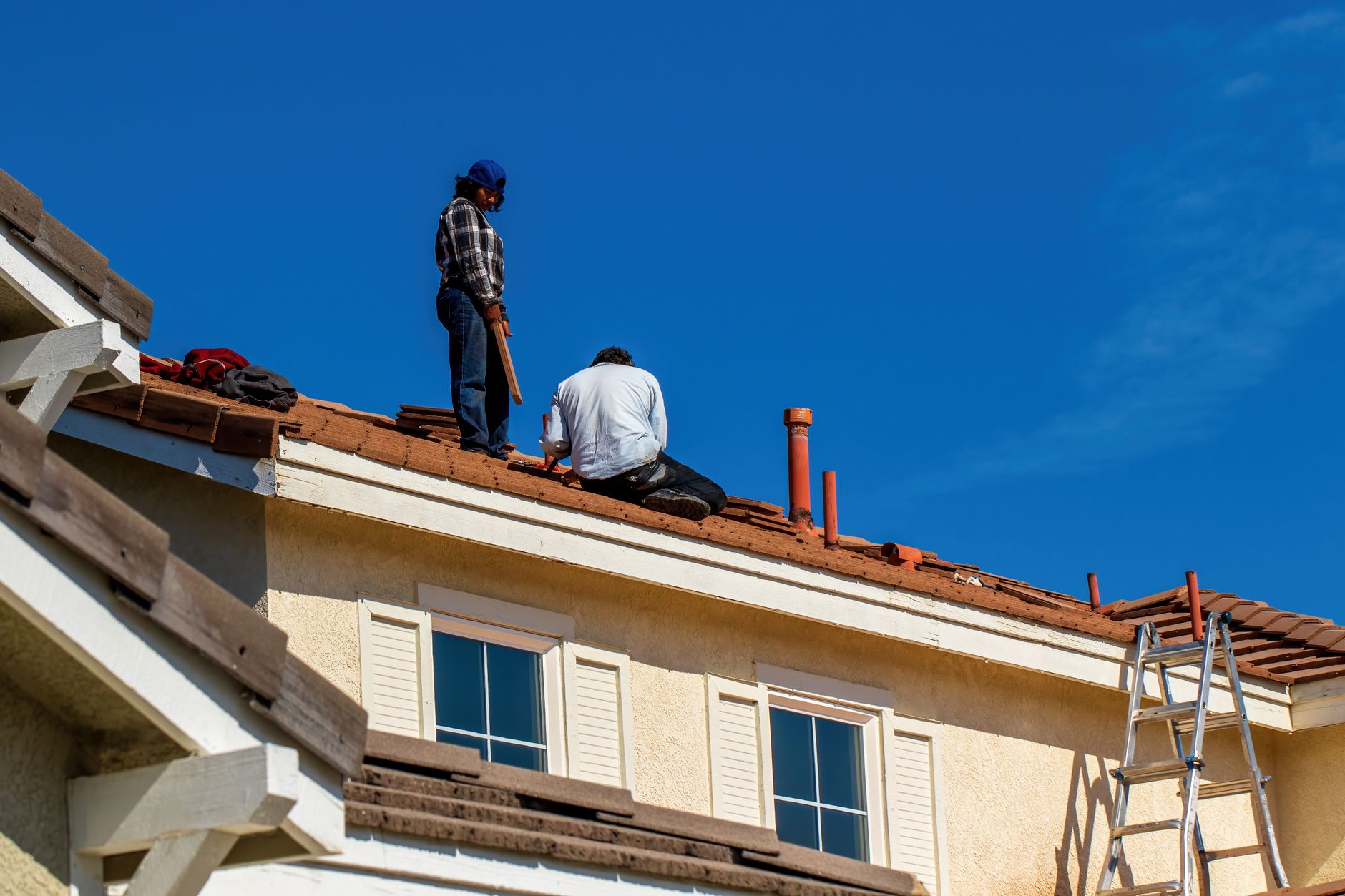 Professional roofer on ladder with roof measuring tools and equipment setup for systematic inspection
